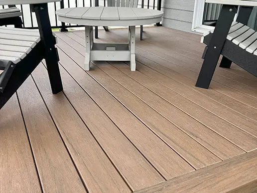 Chairs and a table sit on top of a composite deck.