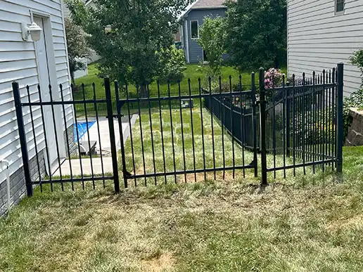 A black fence surrounds an outdoor pool area.