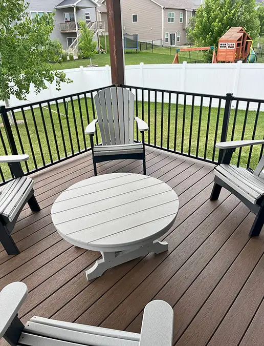 Chairs and a table sit on top of a clean outdoor deck.